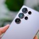 persoana care tine in mana un model de telefon Samsung